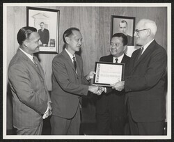 ["Caption: The Agency for International Development has awarded a certificate of cooperation to the East-West Center of the University of Hawaii. Daly C. Lavergne (right), Director of AID's Office of International Training, makes the presentation to Dr. Dai"]