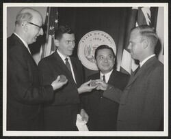 ["Caption: Deputy Attorney General, Peter Lewis, right, is pictured after presenting Statehood Medallions on behalf of Governor Burns to Harold Seidman, left, assistant director, management and organization, Bureau of the Budget, and Howard Schnoor, managem"]