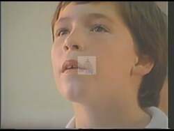 ["In his 1988 campaign ad, Democratic candidate Tim Johnson passionately advocates for educational investment, emphasizing its crucial role in preparing American children for future global competitiveness. Scenes feature Johnson speaking at various podiums, arguing for fair competition and educational reforms, underscored by attentive audiences and patriotic imagery, including American flags and children reciting the Pledge of Allegiance."]