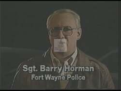 ["In a 1989 campaign ad, Sergeant Barry Horman, in police uniform, sternly addresses the camera from a police station. He vehemently defends Republican presidential candidate Dan Heath, criticizing his opponent Joe Long's misleading advertisements about Heath's stance on crime. Throughout the ad, Horman emphasizes Heaths record and toughness on crime issues."]