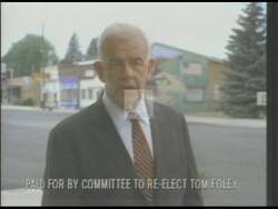 ["In a 1994 campaign ad, Democratic candidate Thomas S. Foley advocates robustly for strengthening America. He emphasizes tough policies on crime, welfare, and immigration, speaking confidently and passionately at various gatherings. Scenes of Foley at podiums and workers at a Boeing factory highlight his focus on national strength, law enforcement, and industrial prowess."]