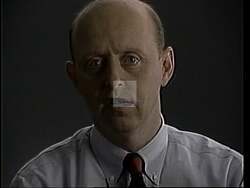 ["In the 1994 presidential campaign ad for James Bernard Longley, the Republican candidate poignantly illustrates his stance on tax reform by using a series of visuals involving a dollar bill. Throughout the ad, Longley is seen tearing, burning, and holding damaged dollar bills, powerfully symbolizing the negative impacts of high taxes and government overspending on ordinary citizens. His serious tone and dramatic visuals underscore his message against the fiscal policies of the current administration."]