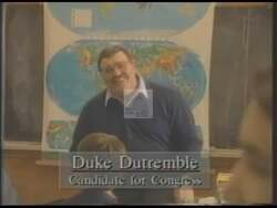 ["The 1994 campaign ad for Democratic candidate Duke Dutremble showcases his interactions with a diverse group of enthusiastic students in a classroom. Throughout the ad, Dutremble is depicted engaging joyfully and attentively with the students, symbolizing his commitment to education, hope, and a diverse, inclusive future. This consistent theme vividly portrays his priorities and care for youth and education."]