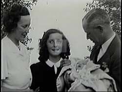 ["In his 1994 political TV ad, Republican John Carroll earnestly communicates his commitment to securing future opportunities for all children. Repeatedly addressing the camera directly, he emphasizes educational values and promises change by advocating for better educational opportunities. The backdrop of family photos and campaign posters reinforces his dedication to future generations."]