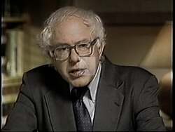 ["In a 1994 political TV ad, Independent Party candidate Bernie Sanders passionately addresses unemployment issues caused by outsourced jobs. Focused scenes depict Sanders at a podium, criticizing corporations for moving jobs overseas and underscoring the urgency of economic revitalization and higher wages through reinvestment in domestic manufacturing and America's workforce."]