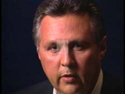 ["In a visually patriotic 1996 political TV ad, Democratic Party candidate Charlie Jones delivers a confident and earnest message. He advocates for change while exuding leadership, standing before American flags in various backgrounds. His direct appeal and passionate gestures center on transitioning from military to political service, aiming to garner broad voter support."]