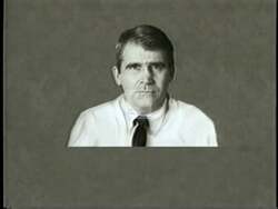 ["The 1994 political TV ad features Kyle McSlarrow ardently advocating for the fictional character Ali Moore's controversial policies in a dystopian setting called \"Ali's World\". The ad presents various scenes of McSlarrow speaking at podiums and in interviews, defending extreme stances against women's rights, assault weapon bans, and promoting contradictory values. The dark, ominous tone underscores the dystopian society being endorsed."]