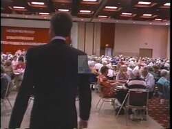 ["In a 1992 campaign ad, Democratic candidate Charlie Wilson speaks at a lively community truck event, celebrating its 10th anniversary. Throughout the ad, Wilson is shown engaging with a cheerful crowd, surrounded by colorfully decorated large trucks, emphasizing his commitment to tradition and local support. The festive atmosphere underscores Wilson's community-focused message."]