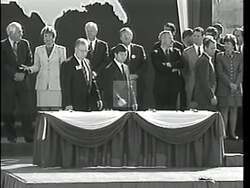 ["In the 1996 political TV ad, Democratic candidate John McKee Spratt Jr. is portrayed as a staunch defender of Medicare and Social Security, vehemently opposing Republicans Larry Bigum and Newt Gingrich, who are shown discussing significant cuts to Medicare. Spratt emphasizes his commitment to protecting these benefits, particularly for seniors, throughout various scenes of him speaking to audiences and directly opposing Gingrich and Bigum's plan."]