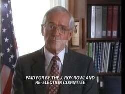 ["In the 1992 campaign ad, Democratic candidate James Roy Rowland advocates passionately for a balanced budget amendment. Staged across various formal settings, Rowland emphasizes fiscal responsibility while standing at podiums, surrounded by American flags, addressing audiences about the urgent need for national budget reform to ensure economic stability."]