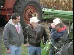 ["In the 1996 campaign ad for Tom Ewing, scenes depict President Ewing confidently addressing the nation and a crowd from a podium, highlighting the success of the \"Farm Policy Reform Act.\" A farmer and government official demonstrate the policy's on-ground impact. The ad emphasizes Ewings leadership in successful agricultural reform."]