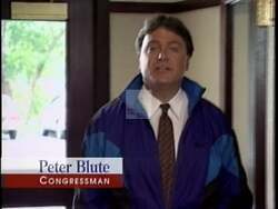 ["In his 1996 presidential campaign ad, Republican candidate Peter I. Blute firmly addresses the camera across various scenes, dismissing negative ads while surrounded by American flags and campaign signs. He portrays determination and resilience, pledging commitment to his constituents and focusing on sincerity rather than political smears."]