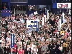["In the 1996 political TV ad for Republican presidential candidate J.C. Watts, he delivers an emotional, inspirational speech from a podium with American flags in the background. Addressing a captivated audience, Watts speaks about personal success and the American dream, emphasizing optimism and the possibility of overcoming obstacles. His demeanor is heartfelt and motivational."]