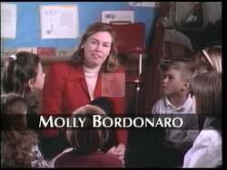 ["In the 1996 presidential campaign ad for Republican Molly Bordonaro, the footage uniquely illustrates a narrative focused on community and school safety. A standout scene portrays a concerned parent passionately addressing a local group about safety issues in schools, echoing a central theme of Bordonaro's platform prioritizing secure educational environments."]
