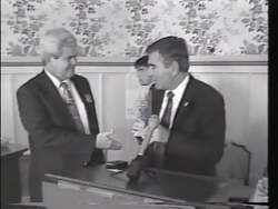 ["The 1996 political TV ad for Democratic candidate Samuel Gejdenson focuses on criticizing his opponent, Ed Munster. The ad portrays Munster in a series of unflattering scenes, highlighting his defensive and troubled demeanor in response to political criticism. With repeated emphasis on Munster's desperation, the ad leverages a dark, ominous tone to paint him unfavorably against an American flag backdrop, aiming to cast doubt on his suitability for office."]