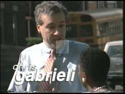 ["In the 1998 presidential campaign ad, Democratic candidate Chris Gabrieli emphasizes the importance of strong probation policies. Addressing community members from a podium, Gabrieli speaks earnestly about enhancing public safety through strict measures against probation violators and embedding effective crime prevention strategies. His determined expression underscores his commitment to these reforms."]