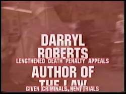 ["In the 1996 political TV ad for Republican candidate Darryl Roberts, he appears repeatedly in pensive and concerned states, predominantly at his desk surrounded by legal documents and the American flag, reflecting on the implications of a controversial legislative proposal. The ad emphasizes his serious demeanor and commitment to contentious issues."]