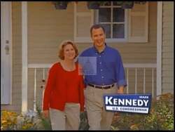 ["In his 2004 presidential campaign ad, Republican Mark Raymond Kennedy confidently addresses the camera from a professional setting. Dressed in a formal suit, he articulates his campaign promises, contrasting his political stance against his opponent, surrounded by subtle American symbols, underscoring his message with earnestness and authority."]