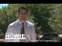 ["In the 2010 campaign ad, Democratic Party candidate Mitchell Howie, standing against familial and patriotic backdrops, communicates his dedication to North Alabama. He highlights his own hard work, service background, and deep local roots, passionately conveying a committed, earnest message designed to resonate strongly with community voters."]