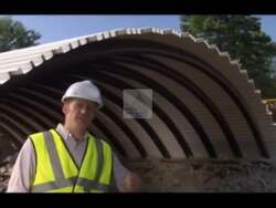 ["In his 2010 presidential campaign ad, Democratic candidate Mike Michaud stood by innovative, portable bridges in various scenes, underscoring his commitment to job creation and technological advancements in infrastructure. The ad showcased lightweight, sustainable construction technology developed by the University of Maine, symbolizing Michaud's focus on forward-thinking economic growth."]