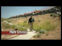 ["In a 2011 political TV ad, Republican Party candidate Mark Amodei criticizes President Obama and Senator Reids economic policies, positioning himself as an advocate for tax cuts and fiscal responsibility. The ad features Amodei speaking sternly to the camera in various political and patriotic settings, emphasizing a need for better economic management and reduced government spending. An animated graph underscores rising debt and spending trends in Nevada and Washington."]