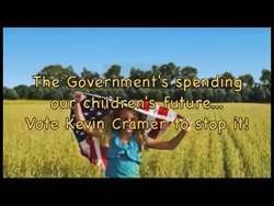 ["In the 2012 political ad, Republican candidate Kevin Cramer emphasizes the urgent need to address the national debt through significant federal spending cuts and a hiring freeze. Positioned at a podium, Cramer passionately advocates for fiscal responsibility and comprehensive budget reforms, using powerful gestures and a patriotic backdrop to emphasize his commitment to overhauling government spending policies. This message resonates with an engaged audience, underscoring his determined stance against increasing national debt."]