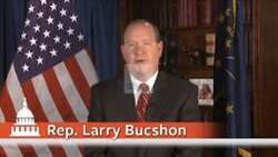 ["In the 2014 campaign ad, Dr. Larry Bucshon, dressed in a professional suit, emphatically addresses constituents from various settings, advocating for his re-election to Congress. He emphasizes his commitment to healthcare reform, fiscal responsibility, and upholding Hoosier values and American liberties, repeatedly appearing with American flags and campaign banners as backdrops."]